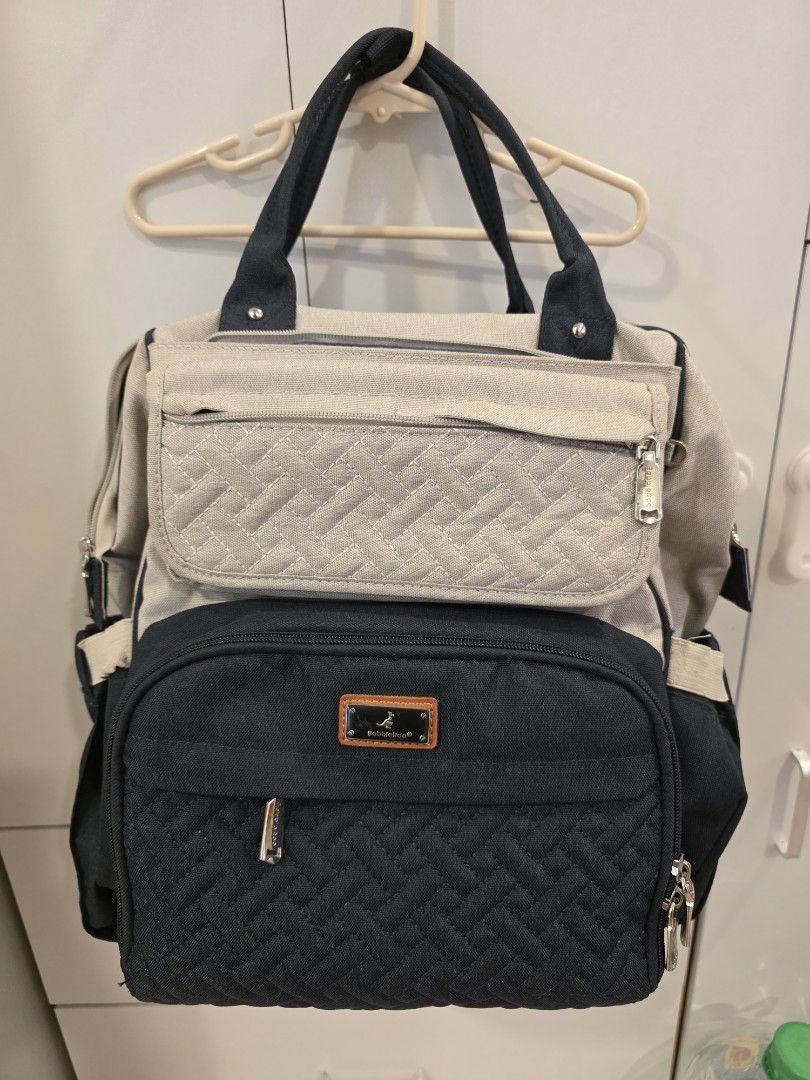 BabbleRoo Diaper Bag Backpack Navy Blue Quilted (Category: Diaper Bags & Wetbags) located in Cebu City. Submitted by gca13 (Listing ID 1447950800, Image 1). Description: - Brand: BabbleRoo - Color: Navy blue - Style: Quilted diaper bag backpack - Front pocket: Beige with textured pattern - Interior: Multiple compartments for organization - Exterior: Side mesh pocket - Zippers: Silver-toned - Perfect for carrying all your baby essentials!.