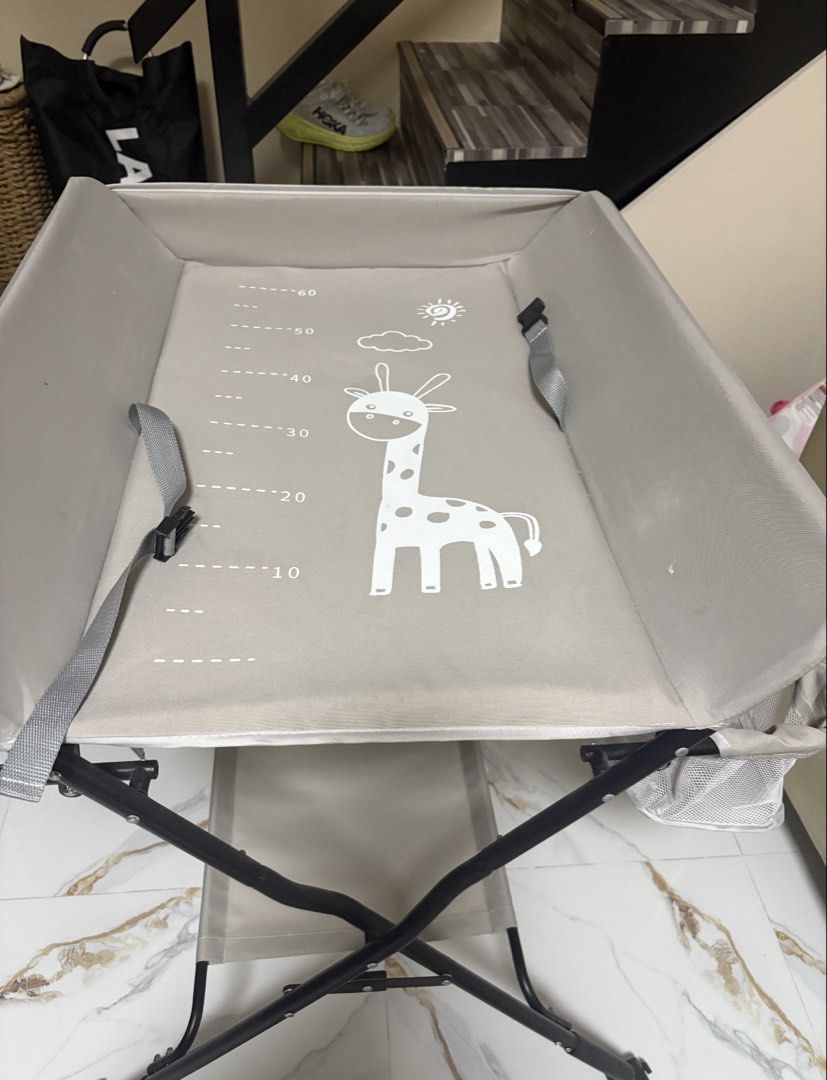 Baby Changing Station with Giraffe Design (Category: Changing Mats & Accessories) located in Baguio. Submitted by modclaris99819 (Listing ID 1448072748, Image 2). Description: - Adorable giraffe print design - Portable and easy to fold for convenient storage - Built-in safety straps for your baby's security - Handy side basket for keeping essentials within reach - Ideal solution for maximizing space in smaller homes - Features height markings for