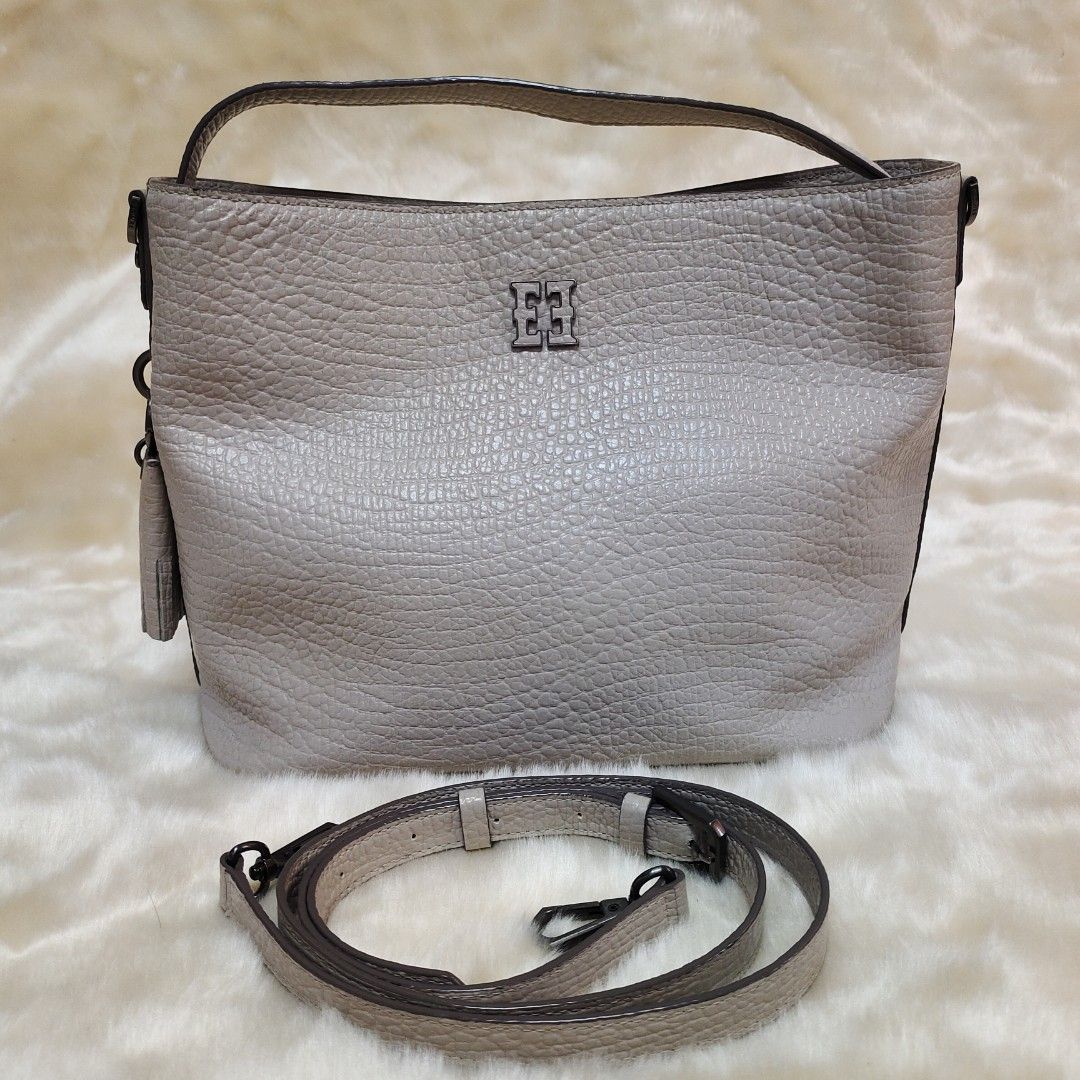 Esquire Leather Handbag with Sling Strap (Category: Shoulder Bags) located in Binan City. Submitted by apparelsbyeve (Listing ID 1447973993, Image 2). Description: PRELOVED - AUTHENTIC - Grey textured leather handbag - Top handle and detachable sling strap - Zip pocket on the back - Tassel detail included - Phone shown for size reference: iphone 15 pro.