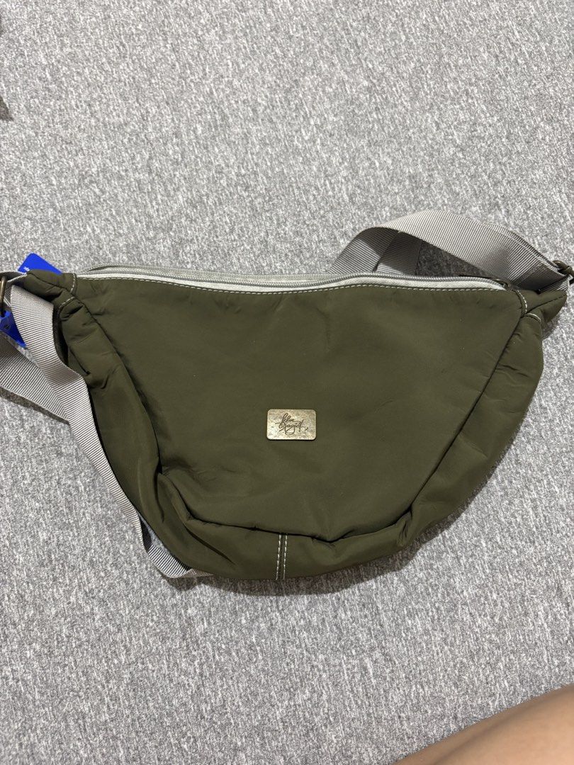 Blue Magic Olive Green Nylon Waist Bag (Category: Belt bags, Clutches and Pouches) located in Bulacan. Submitted by akkimsantos (Listing ID 1448002896, Image 1). Description: - Olive green waist bag - Brand: Blue Magic - Material: Nylon - Features: Main zippered compartment, adjustable strap - Unique detail: Blue Magic logo on zipper pull - Benefits: Hands-free carrying, great for essentials - Use cases: Perfect for travel or daily use.