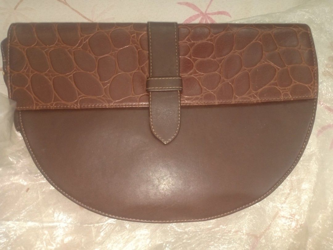 Brown Leather Crocodile Embossed Clutch Bag with Strap (Category: Clutches) located in Manila. Submitted by macchi1216 (Listing ID 1447976450, Image 1). Description: - Brown leather clutch - Crocodile embossed flap - Detachable strap with buckle - Zipper closure inside - Patterned lining - Ideal for evenings out or as a statement piece.