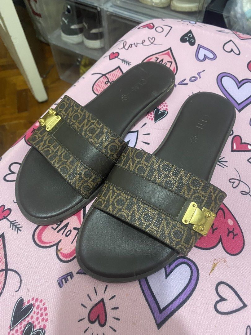 CLN Brown Monogram Slides with Gold Buckle (Category: Flats & Sandals) located in Taguig. Submitted by mumpreloveddd (Listing ID 1448065139, Image 1). Description: - Brand: CLN - Color: Brown - Design: Monogram pattern on strap - Detail: Gold buckle accent - Style: Slip-on - Occasion: Casual wear.