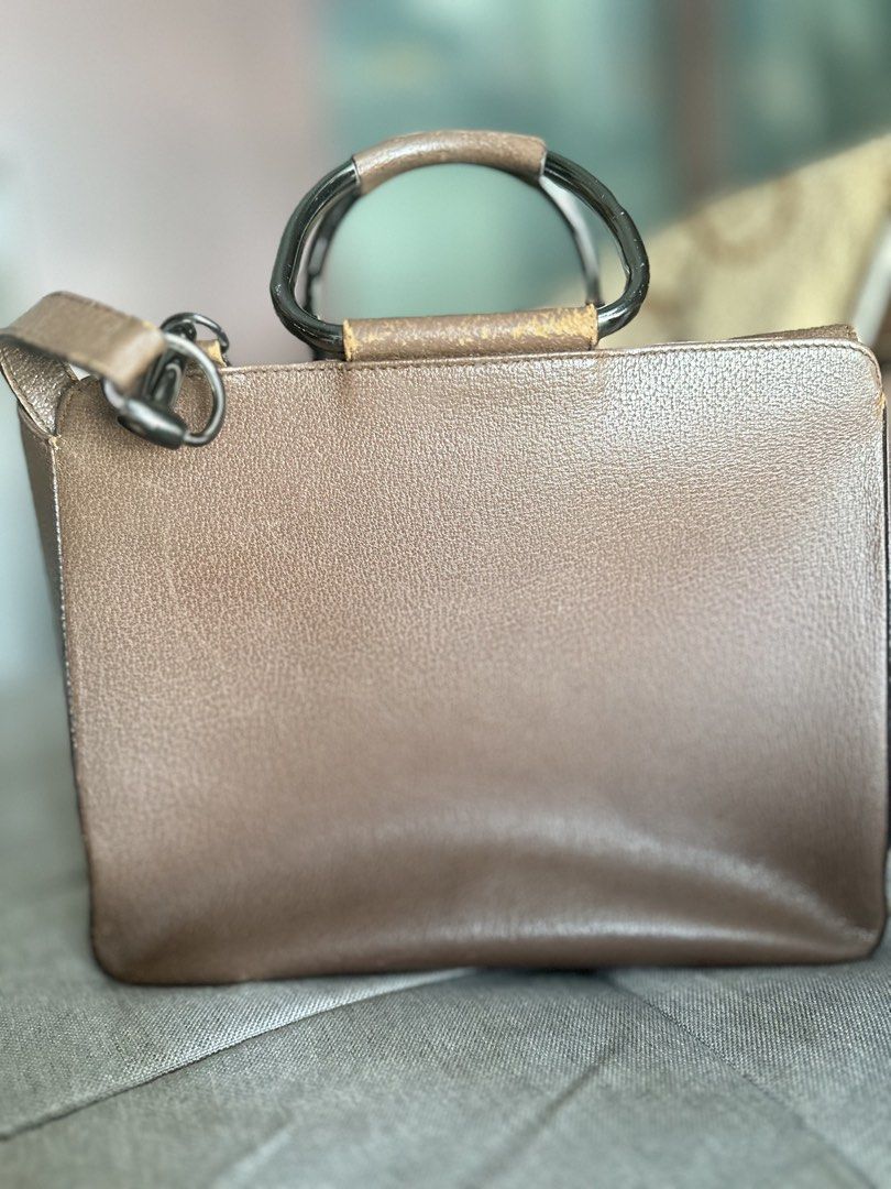 Gucci Brown Leather Top Handle Bag (Category: Luxury Bags & Wallets) located in Mandaluyong City. Submitted by TheWeekendProject (Listing ID 1447986527, Image 3). Description: - Authentic brown leather Gucci handbag - Features a front flap pocket with metal snap closure - Unique metal and leather top handle - Interior zippered pocket - Pre-owned vintage condition. - Leather exterior shows minor scuffs and rubbing consistent with age. - Hardware h