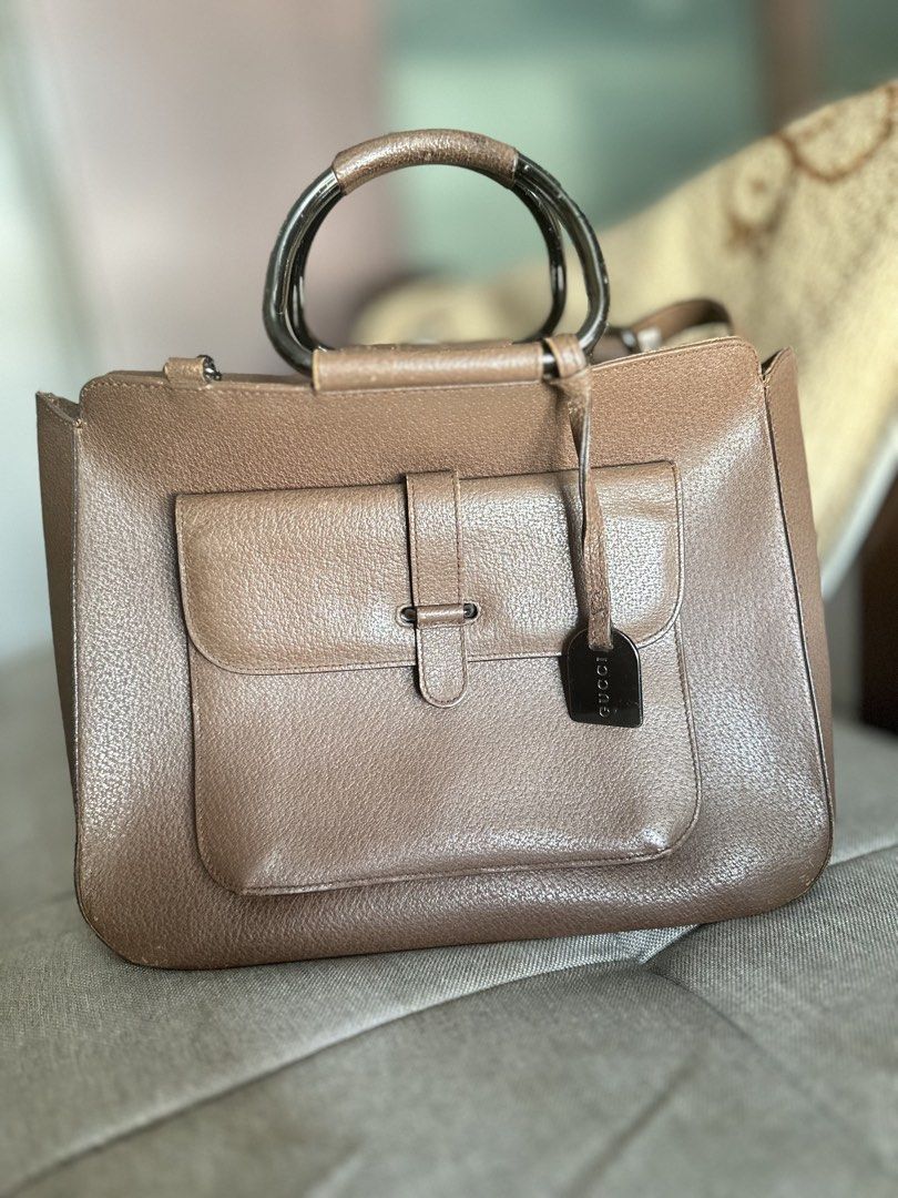 Gucci Brown Leather Top Handle Bag (Category: Luxury Bags & Wallets) located in Mandaluyong City. Submitted by TheWeekendProject (Listing ID 1447986527, Image 1). Description: - Authentic brown leather Gucci handbag - Features a front flap pocket with metal snap closure - Unique metal and leather top handle - Interior zippered pocket - Pre-owned vintage condition. - Leather exterior shows minor scuffs and rubbing consistent with age. - Hardware h