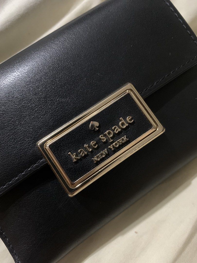 Kate Spade New York Black Leather Wallet (Category: Wallets & Card holders) located in Manila. Submitted by gracefilledshop (Listing ID 1448012613, Image 2). Description: - Brand: Kate Spade New York - Material: Black Leather - Features: Multiple card slots - Exterior: Gold-tone clasp with brand name - Condition: Clean exterior, minor wear on inside lining near the fold - Barely used, na-stock lang sa cabinet - Original price: P4,500.