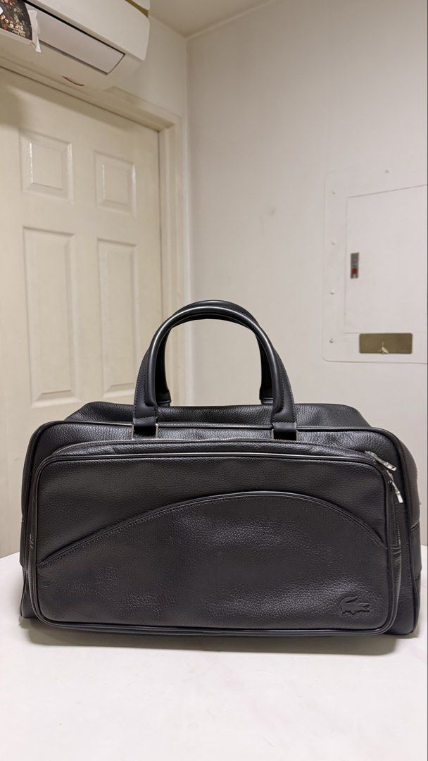 Lacoste Black Leather Duffle Bag (Category: Luxury Bags & Wallets) located in Quezon City. Submitted by strawberryscorpio (Listing ID 1447990611, Image 1). Description: RFS: not using it anymore Used 2-3x lang. - Authentic Lacoste black leather duffle bag - Main zippered compartment - Front zippered pocket - Textured leather finish - Sturdy and comfortable handles - Includes original Lacoste dust bag.
