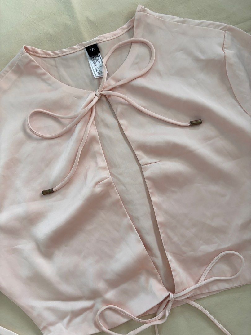 Light Pink Satin Tie-Front Long Sleeve Top (Category: Longsleeves) located in Malabon City. Submitted by ellaeiry (Listing ID 1447981876, Image 2). Description: Size: XS-S [S on Tag] flat lay measurements: w: 17” in. l: 14” in. Brand: Amoricon Apeioar Condition: No flaws Price: PHP 179 - color may vary due to lighting - as a second-hand garment, it may have details that went unnoticed - please don’t hesitate to message me for any inquiries, thank