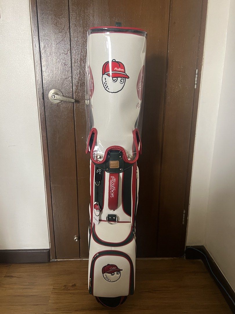Malbon x Coca Cola Golf Bag (Category: Golf) located in Manila. Submitted by kensoncai8 (Listing ID 1448032502, Image 2). Description: - Malbon x Coca-Cola collaboration golf bag - Classic white color with red and green accents - Features iconic Coca-Cola logo and Malbon branding - Ample storage space for clubs and golf essentials - Comes with a clear rain cover - Ideal for golf enthusiasts with a love for retro style.