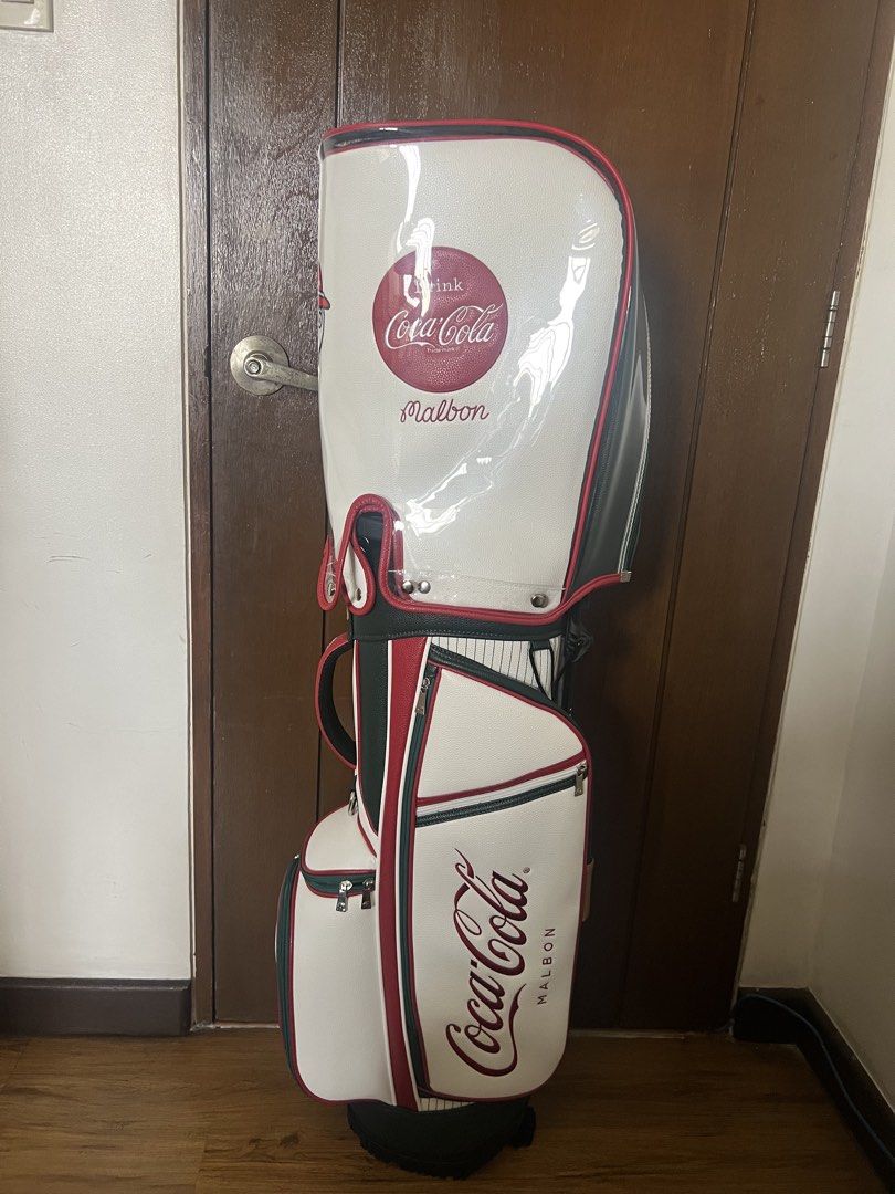 Malbon x Coca Cola Golf Bag (Category: Golf) located in Manila. Submitted by kensoncai8 (Listing ID 1448032502, Image 3). Description: - Malbon x Coca-Cola collaboration golf bag - Classic white color with red and green accents - Features iconic Coca-Cola logo and Malbon branding - Ample storage space for clubs and golf essentials - Comes with a clear rain cover - Ideal for golf enthusiasts with a love for retro style.
