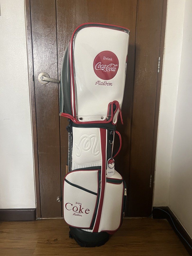 Malbon x Coca Cola Golf Bag (Category: Golf) located in Manila. Submitted by kensoncai8 (Listing ID 1448032502, Image 1). Description: - Malbon x Coca-Cola collaboration golf bag - Classic white color with red and green accents - Features iconic Coca-Cola logo and Malbon branding - Ample storage space for clubs and golf essentials - Comes with a clear rain cover - Ideal for golf enthusiasts with a love for retro style.