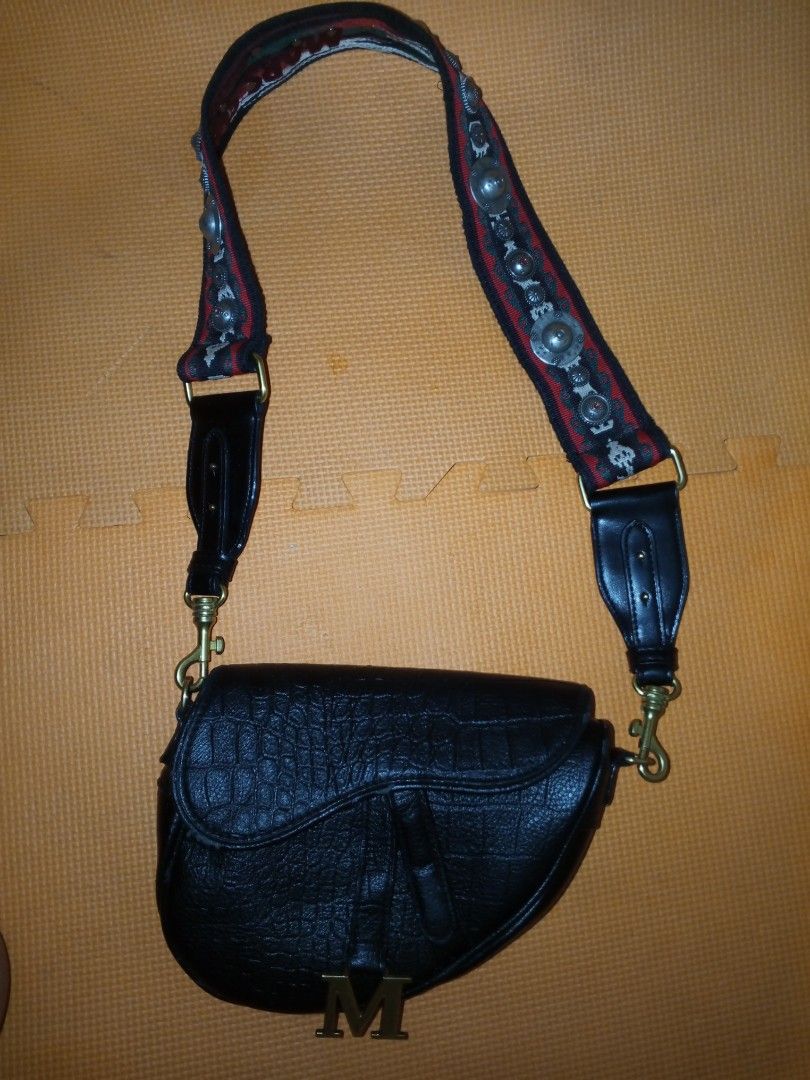 Mars Sharing Tokyo Black Croc Saddle Bag with Embellished Strap (Category: Cross-body Bags) located in Bulacan. Submitted by keroro1982 (Listing ID 1448004481, Image 2). Description: - Stylish black saddle bag - Features a sophisticated croc texture - Adorned with a gold 'M' initial charm - Comes with a unique, embellished strap - Strap details 'Mars Sharing Tokyo' - Highly versatile for casual or dressy looks.