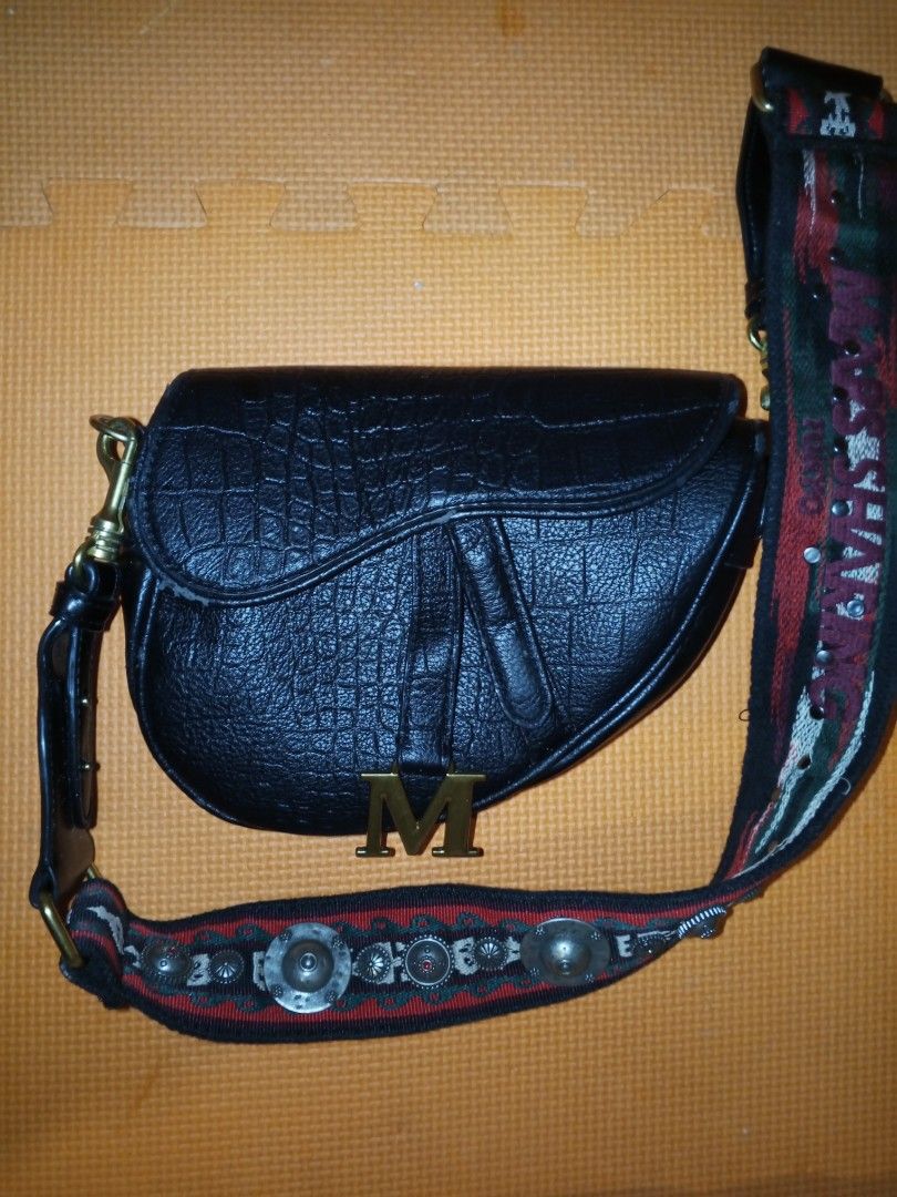 Mars Sharing Tokyo Black Croc Saddle Bag with Embellished Strap (Category: Cross-body Bags) located in Bulacan. Submitted by keroro1982 (Listing ID 1448004481, Image 3). Description: - Stylish black saddle bag - Features a sophisticated croc texture - Adorned with a gold 'M' initial charm - Comes with a unique, embellished strap - Strap details 'Mars Sharing Tokyo' - Highly versatile for casual or dressy looks.