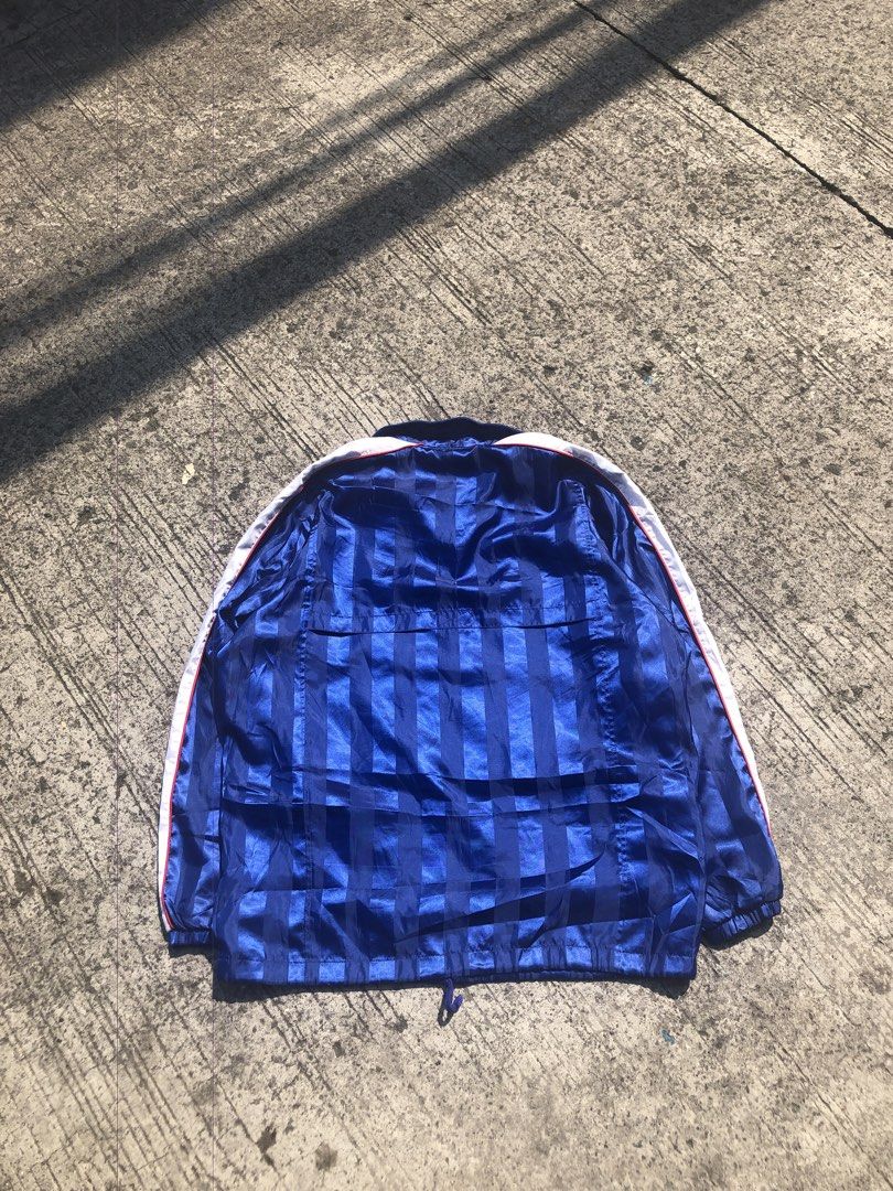 Nike Blue Striped Track Jacket (Category: Activewear) located in Caloocan City. Submitted by thriftniotep. (Listing ID 1448014853, Image 2). Description: - Classic blue and white Nike track jacket - Features stylish stripes on blue sections - Full zip-up front with a comfortable collar - White sleeves accented with a red stripe detail - Iconic Nike logo on chest and sleeve cuff - Adjustable drawstring at the hem for a custom fit.