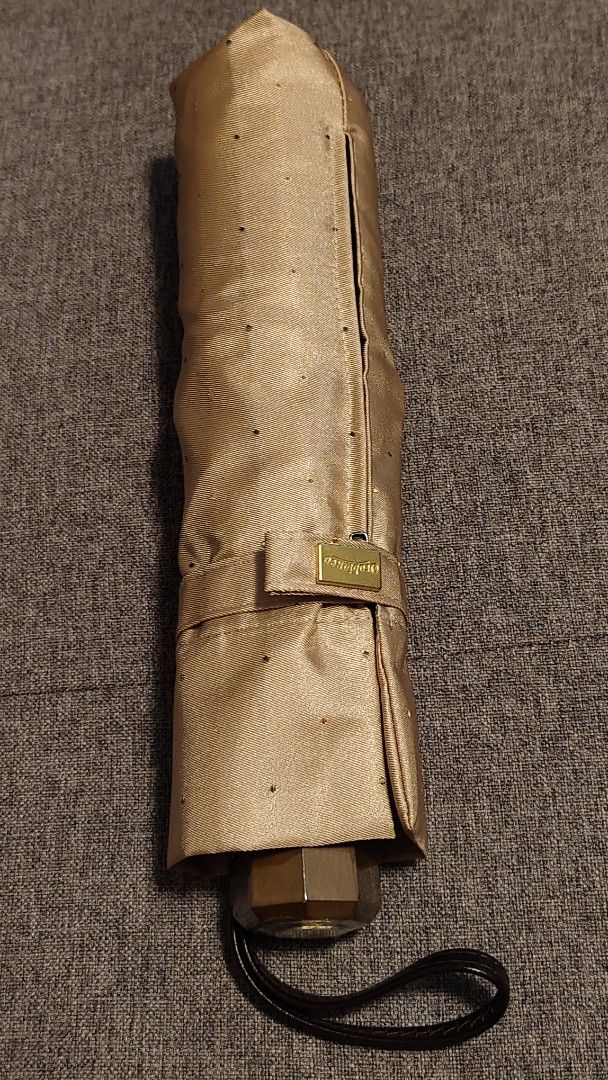 AUTHENTIC Orobianco Folding Umbrella - Beige with Black Dots (Category: Umbrellas) located in Davao. Submitted by warmdeer-4ae1 (Listing ID 1448062864, Image 1). Description: - Authentic OROBIANCO ompact folding umbrella - Beige fabric with small black dots - Includes a matching sleeve with zipper closure - Ornate gold emblem on the handle - Easy to carry, ideal for unexpected rain.