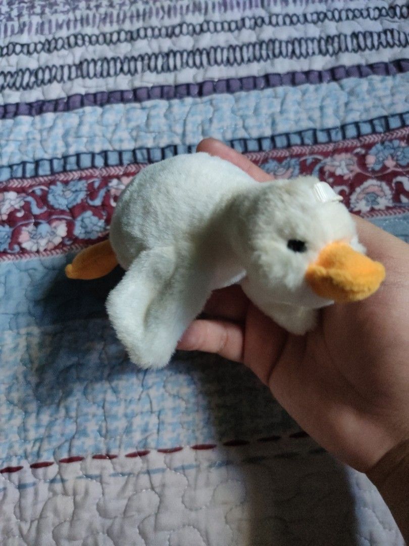 Plush duck (Category: Plushies & Soft Toys) located in Santiago. Submitted by johnmichael1213 (Listing ID 1447896868, Image 3). Description: This plush white duck keyring shares characteristics with various "kawaii" goose or duck cartoon doll pendants, often featuring gold-tone hardware. Design: White plush body with a prominent orange beak, designed as a decorative keychain or bag charm. Hardware: Includes a gold-colored ring and lobster clasp f