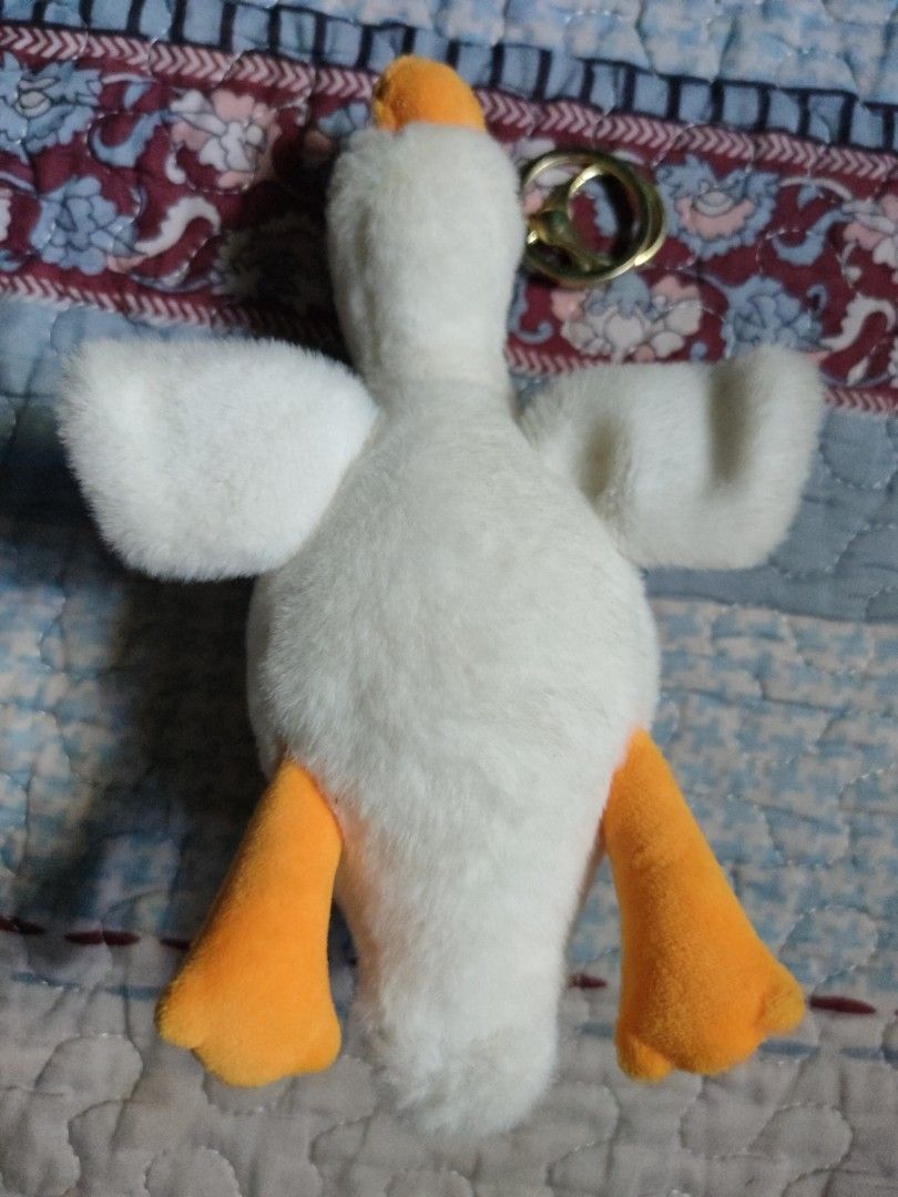 Plush duck (Category: Plushies & Soft Toys) located in Santiago. Submitted by johnmichael1213 (Listing ID 1447896868, Image 2). Description: This plush white duck keyring shares characteristics with various "kawaii" goose or duck cartoon doll pendants, often featuring gold-tone hardware. Design: White plush body with a prominent orange beak, designed as a decorative keychain or bag charm. Hardware: Includes a gold-colored ring and lobster clasp f