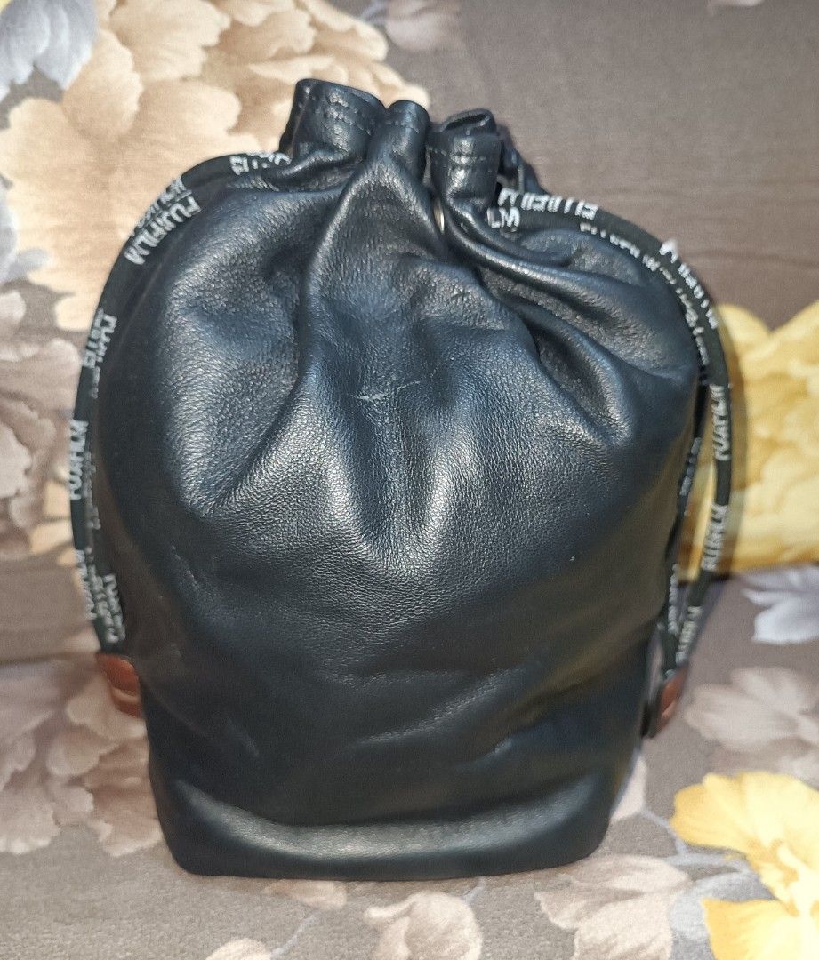 Preloved Fujifilm Leather Drawstring Pouch Bag (Category: Camera Bags & Carriers) located in Pasig City. Submitted by bcthriftedzoneonlineshop (Listing ID 1447994605, Image 2). Description: - Genuine Fujifilm black leather drawstring pouch. - Features embossed Fujifilm logo on the front. - Includes small interior pockets for organization. - Drawstring is branded with Fujifilm lettering. - Ideal for protecting camera lenses, filters, or other smal