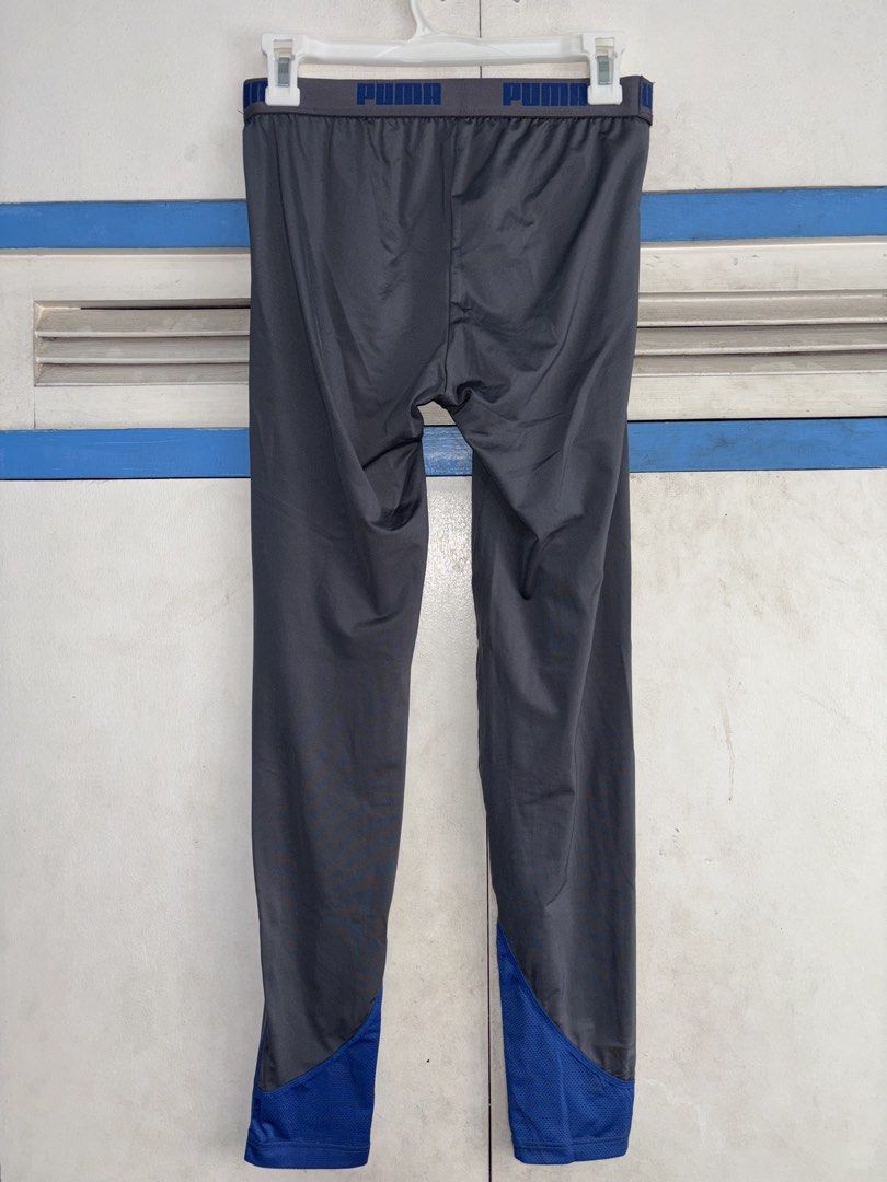 Puma Men's Grey Athletic Tights Size S (Category: Activewear) located in Pasig City. Submitted by timmybatoon (Listing ID 1448076795, Image 2). Description: Puma Compression Tights (GRAY) Size on tag: S (MENS) Dimensions: 27-32inW x 36inL Price: 800 - Grey Puma athletic tights - Blue accents on sides and ankles - Puma logo on left leg - Elastic waistband with Puma branding - Made in Vietnam - Ideal for workouts or running.