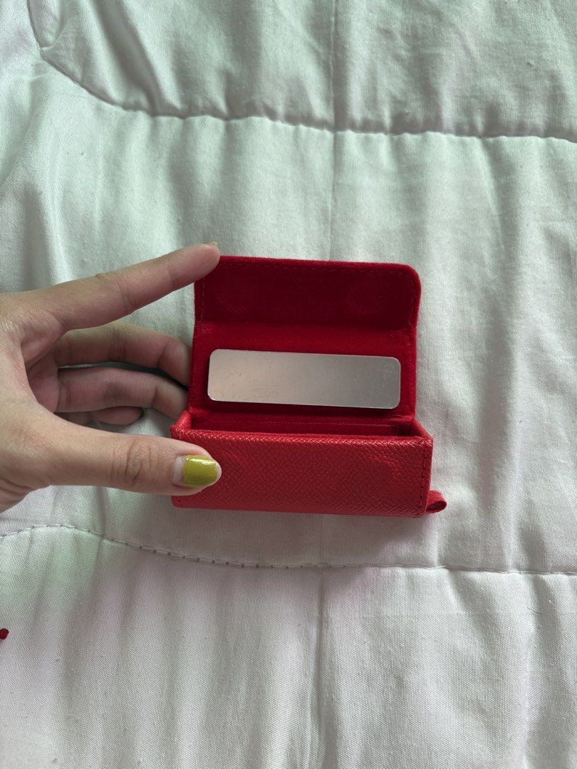 Sunnies Face Red Compact Mirror Case (Category: Mirrors) located in Manila. Submitted by _foryou (Listing ID 1447960459, Image 2). Description: - SUNNIERACE Red Compact Mirror Case - Features a built-in mirror - Small and portable for on-the-go use - Leather-like texture for a stylish feel - Easy to open with a small tab - Ideal for quick makeup touch-ups.
