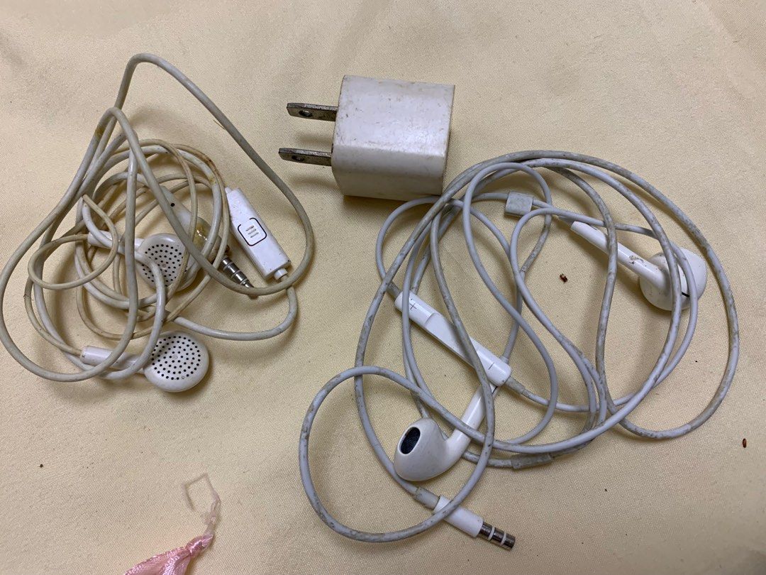 Take all Earphones and Charger Set (Category: Earphones) located in Manila. Submitted by labubu_lovelovelove (Listing ID 1448024949, Image 2). Description: - Set includes: 2 pairs of Apple earphones and 1 Apple wall charger. - Color: All white. - Condition: Shows some signs of wear on earphone cables and earbuds. Charger plug has slight discoloration. - Functionality: Both earphones and charger are working perfectly..