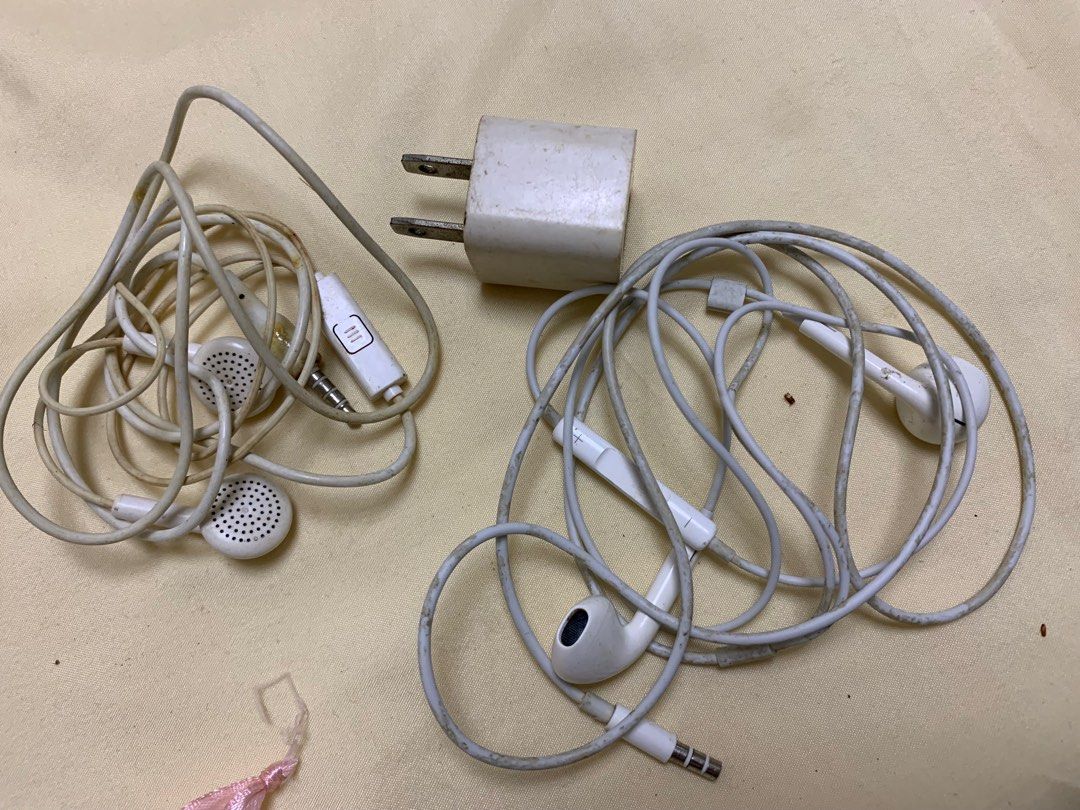 Take all Earphones and Charger Set (Category: Earphones) located in Manila. Submitted by labubu_lovelovelove (Listing ID 1448024949, Image 1). Description: - Set includes: 2 pairs of Apple earphones and 1 Apple wall charger. - Color: All white. - Condition: Shows some signs of wear on earphone cables and earbuds. Charger plug has slight discoloration. - Functionality: Both earphones and charger are working perfectly..