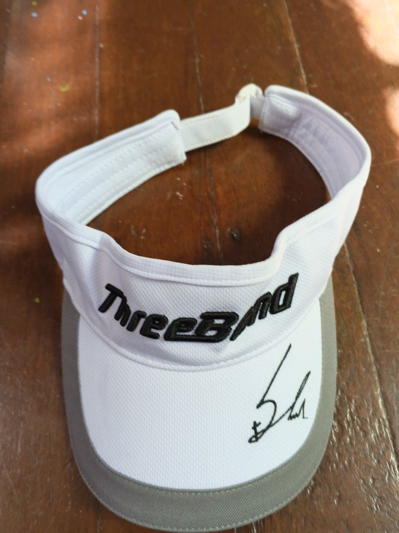 ThreeBond Golf Visor with Autograph (Category: Golf) located in Caloocan City. Submitted by the_good_item05 (Listing ID 1448077048, Image 1). Description: - White and grey golf visor - Embroidered black 'ThreeBond' logo - Black autograph on the brim - Adjustable strap for a comfortable fit - Ideal for sunny days on the golf course.