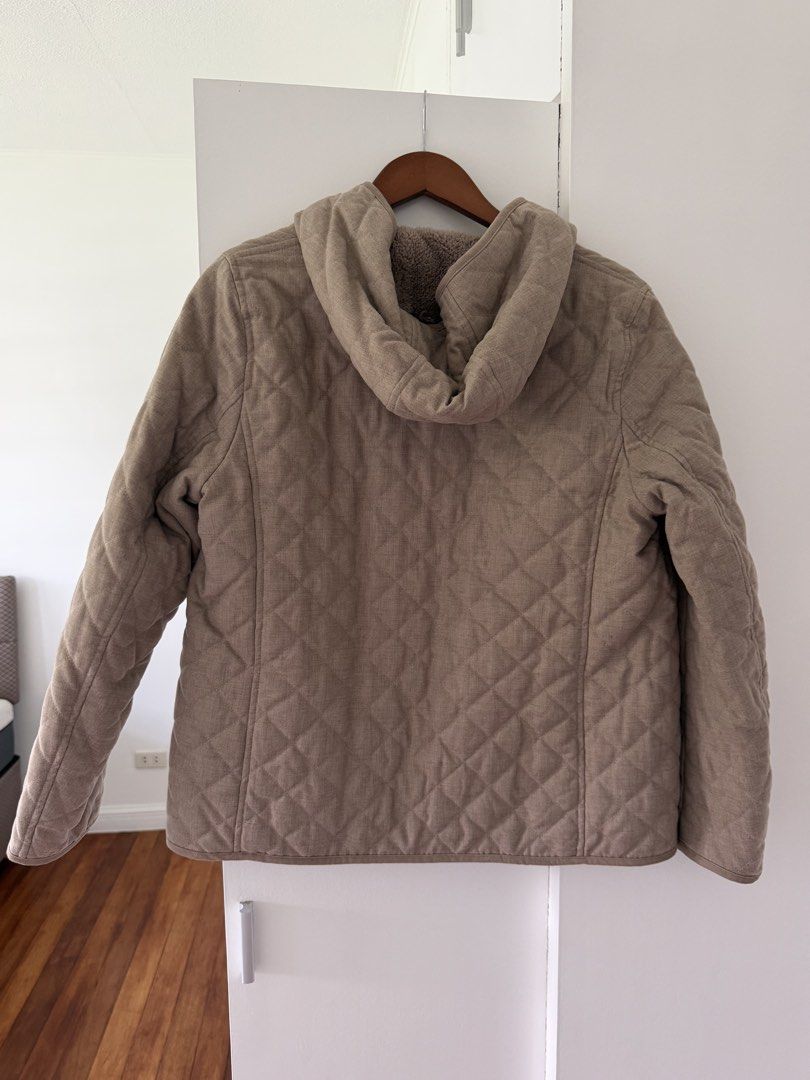 Uniqlo Quilted Hooded Jacket with Lining (Category: Coats, Jackets and Outerwear) located in Taguig. Submitted by onein.oneout_declutter (Listing ID 1447895483, Image 2). Description: - Cozy quilted jacket - Warm sherpa lining - Features a hood - Button-up front - Neutral beige color - Great for layering - Perfect for cooler weather.
