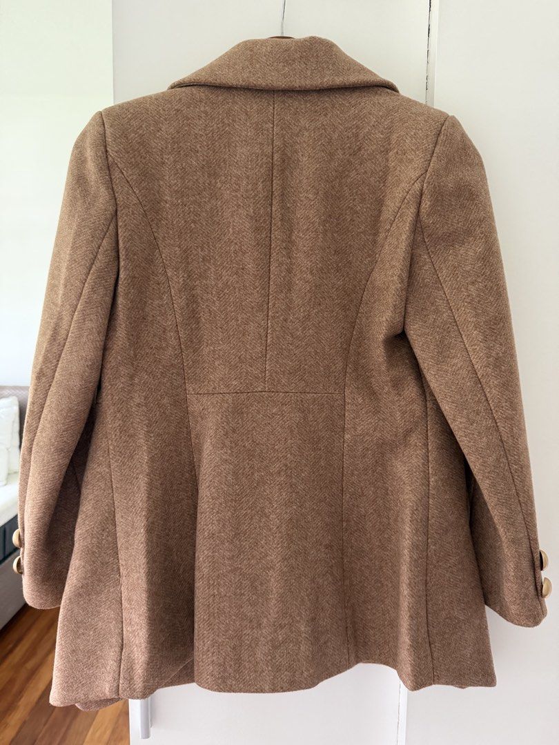 Well Suited Double-Breasted Wool Blend Coat (Category: Coats, Jackets and Outerwear) located in Taguig. Submitted by onein.oneout_declutter (Listing ID 1447896707, Image 2). Description: - Classic brown coat - Wool blend texture - Double-breasted front - Gold-tone buttons - Tailored fit - Notched lapel - Versatile for dressing up or down - Ideal for cooler weather.