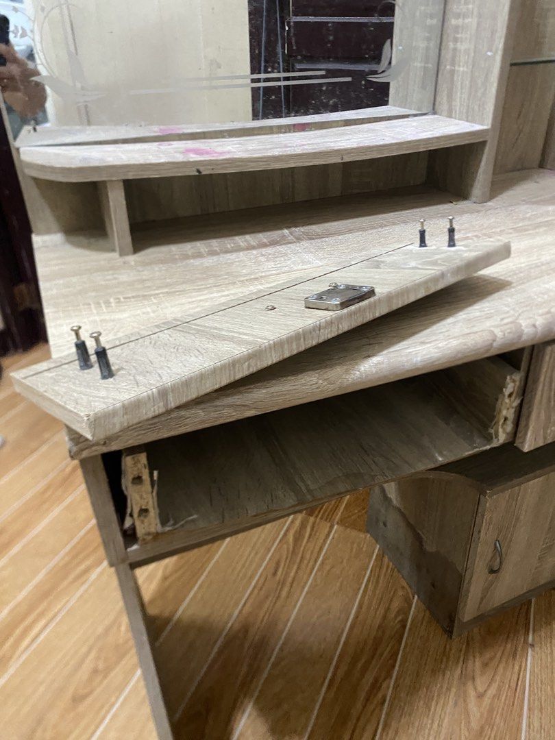 Wooden Dressing Table with Mirror and Drawers (Category: Tables & Sets) located in Bulacan. Submitted by shielamagd22715 (Listing ID 1447928566, Image 3). Description: - Light wood grain dressing table - Includes a mirror - Two drawers with locks for secure storage - Features a small cabinet with a door - Note: Some water damage on the legs - Note: One shelf on the side is loose - Sold as is.