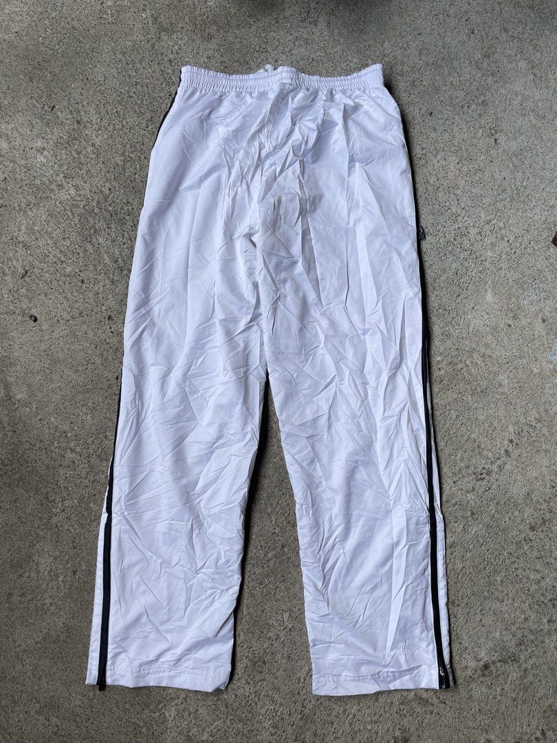 Adidas White Track Pants with Black Stripes (Category: Jeans) located in Siniloan. Submitted by rethr1ft (Listing ID 1448169670, Image 3). Description: - White Adidas track pants - Size Medium (30-34 waist) (39 length) - Classic three stripes down the sides - Drawstring waist for adjustable fit - Adidas logo on lower leg - Made in Japan - Ideal for sports or casual wear.