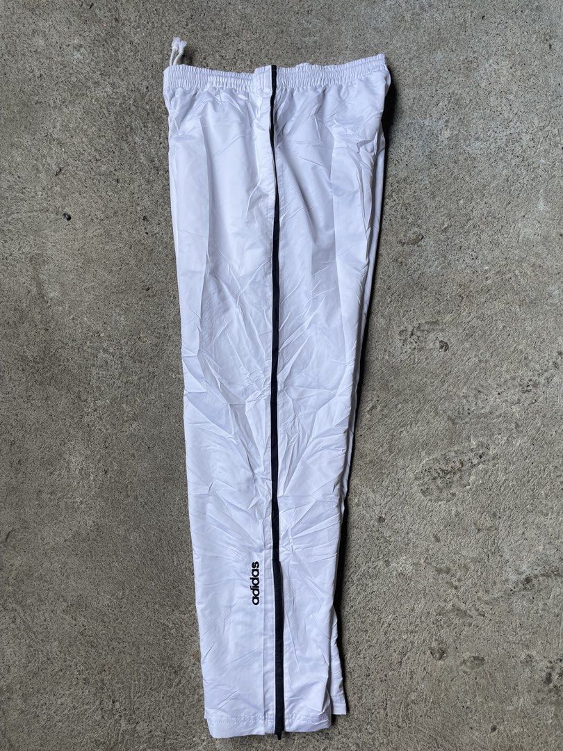 Adidas White Track Pants with Black Stripes (Category: Jeans) located in Siniloan. Submitted by rethr1ft (Listing ID 1448169670, Image 2). Description: - White Adidas track pants - Size Medium (30-34 waist) (39 length) - Classic three stripes down the sides - Drawstring waist for adjustable fit - Adidas logo on lower leg - Made in Japan - Ideal for sports or casual wear.
