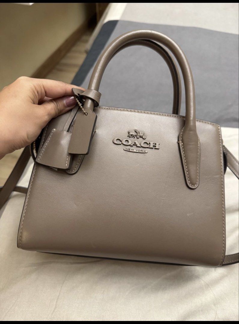 Authentic Coach mini Andrea Bag in chocolate color (Category: Luxury Bags & Wallets) located in Alaminos. Submitted by wearme_imnice (Listing ID 1448086197, Image 2). Description: - Genuine Coach top handle bag in taupe. - Made from authentic leather. - Features elegant gold hardware details. - Comes with a detachable shoulder strap for versatile carrying. - Includes a small, matching leather tag. - Interior is clean and well-maintained. - Ideal 