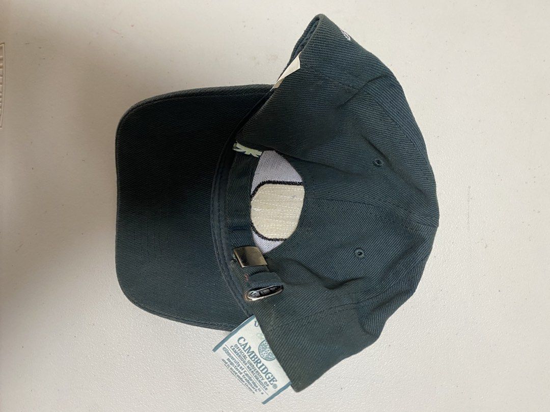 Cambridge University Official Merchandise Cap (Category: Caps & Hats) located in Taguig. Submitted by thriftdee (Listing ID 1448126640, Image 3). Description: - Official dark green cap from Cambridge University - Features the iconic university crest embroidered on the front - Adjustable strap at the back for a comfortable fit - Ideal for Cambridge alumni, students, or fans.