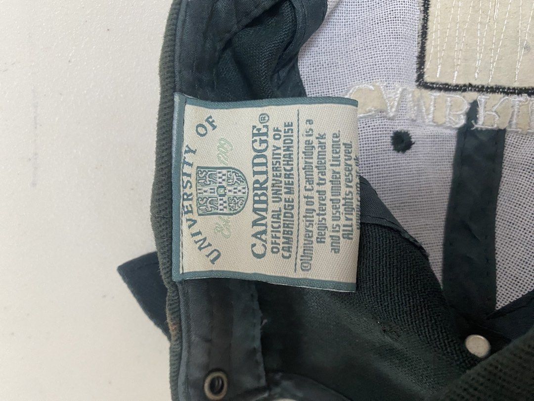 Cambridge University Official Merchandise Cap (Category: Caps & Hats) located in Taguig. Submitted by thriftdee (Listing ID 1448126640, Image 2). Description: - Official dark green cap from Cambridge University - Features the iconic university crest embroidered on the front - Adjustable strap at the back for a comfortable fit - Ideal for Cambridge alumni, students, or fans.