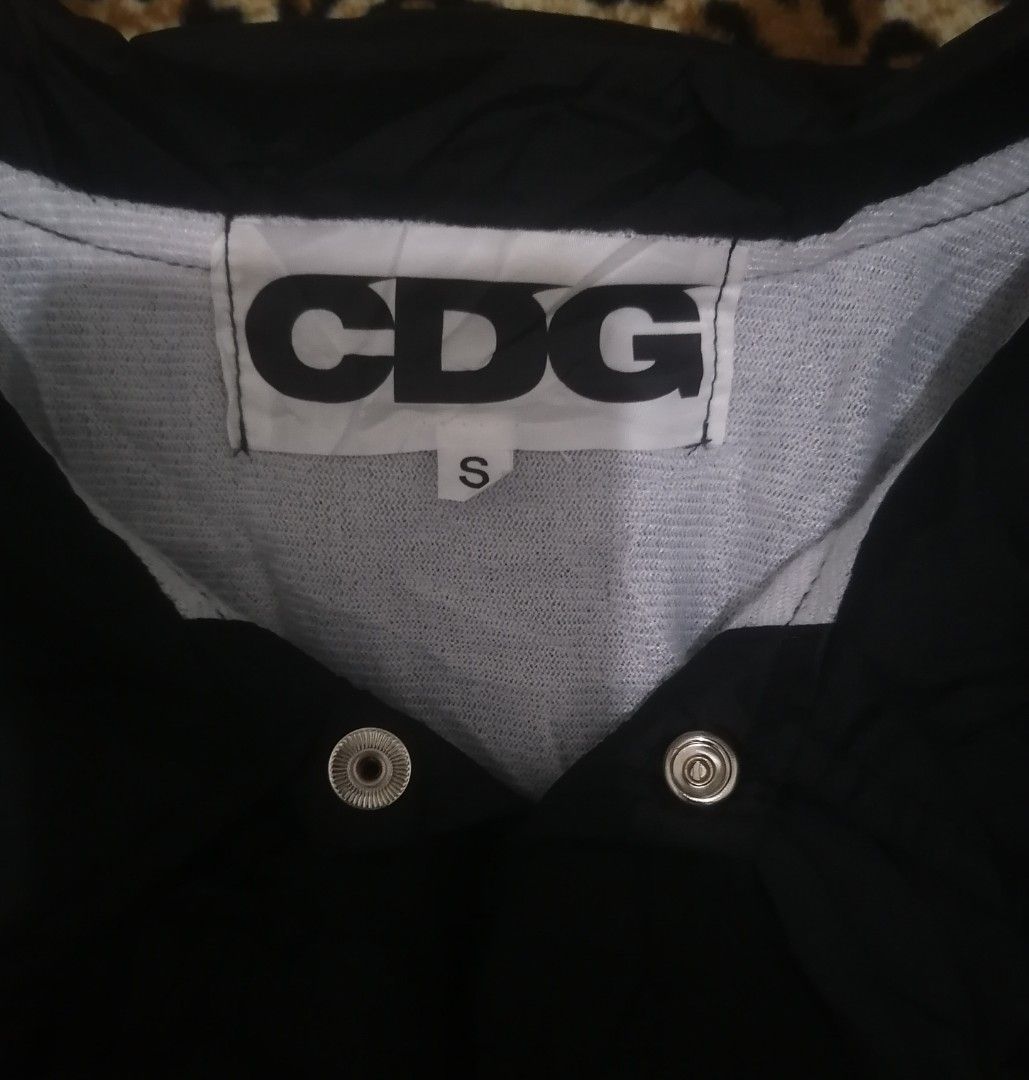 CDG Comme des Garçons Black Coach Jacket (Category: Coats, Jackets and Outerwear) located in Cebu City. Submitted by roadthrift (Listing ID 1448123145, Image 3). Description: - Black CDG Jacket - Size: S - 'CDG' logo prominently displayed on the back - Inner lining features 'MY ENERGY COMES FROM FREEDOM' print - Snap button closure for easy wear - Essential addition to any streetwear collection - Excellent condition .