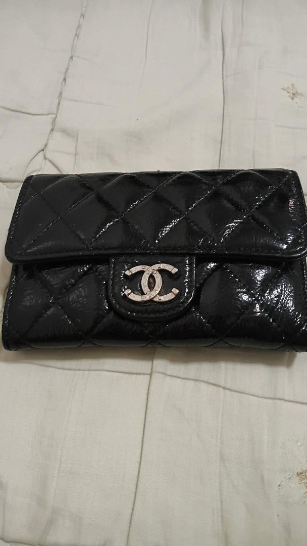 Chanel Black Patent Quilted Wallet (Category: Luxury Bags & Wallets) located in Manila. Submitted by melsalgado42455 (Listing ID 1448183348, Image 1). Description: - Black Patent Leather Chanel Wallet - Classic Quilted Design - Iconic CC Logo - Interior: Card Slots & Zip Pocket - Made in Italy - Shows some signs of wear on edges and interior.