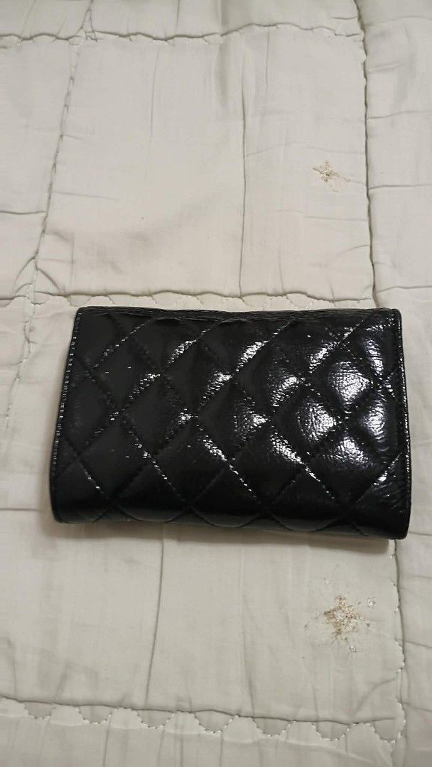 Chanel Black Patent Quilted Wallet (Category: Luxury Bags & Wallets) located in Manila. Submitted by melsalgado42455 (Listing ID 1448183348, Image 2). Description: - Black Patent Leather Chanel Wallet - Classic Quilted Design - Iconic CC Logo - Interior: Card Slots & Zip Pocket - Made in Italy - Shows some signs of wear on edges and interior.