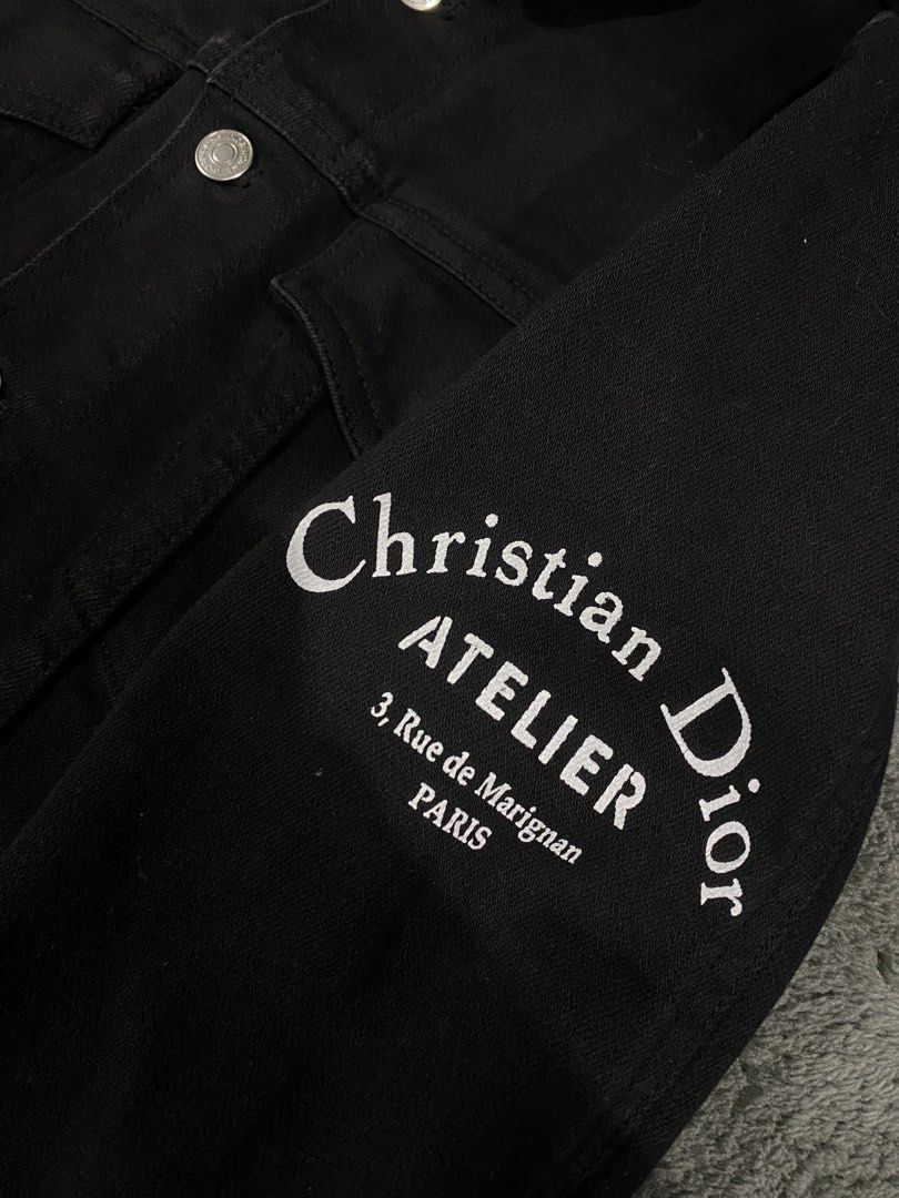 Christian Dior Atelier Black Denim Jacket (Category: Coats, Jackets and Outerwear) located in Leganes. Submitted by wisehandpick (Listing ID 1448262891, Image 3). Description: - Authentic Christian Dior black denim jacket - 'ATELIER 3, Rue de Marignan PARIS' print on back and sleeve - Classic button-up style - Two chest pockets - Silver-tone buttons with Dior branding - Dior tag inside Christian Dior denim jacket Like new condition 10/10 Kindly c