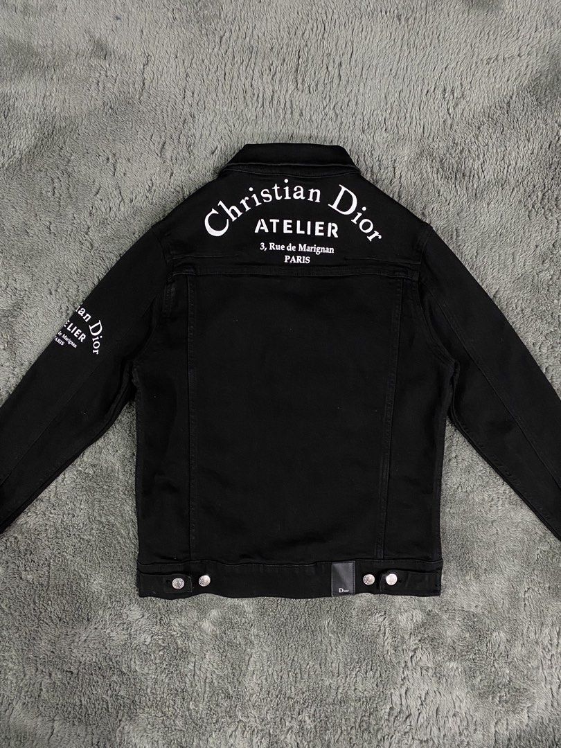 Christian Dior Atelier Black Denim Jacket (Category: Coats, Jackets and Outerwear) located in Leganes. Submitted by wisehandpick (Listing ID 1448262891, Image 1). Description: - Authentic Christian Dior black denim jacket - 'ATELIER 3, Rue de Marignan PARIS' print on back and sleeve - Classic button-up style - Two chest pockets - Silver-tone buttons with Dior branding - Dior tag inside Christian Dior denim jacket Like new condition 10/10 Kindly c