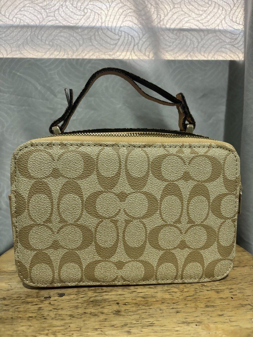 Coach Signature Canvas Mini Vanity Case Bag (Category: Luxury Bags & Wallets) located in Manila. Submitted by mommysoleil (Listing ID 1448172871, Image 2). Description: - Coach mini vanity case - Signature canvas in tan and brown monogram print - Features a top handle - Includes a detachable crossbody strap - Front pocket with Coach logo hardware - Secure zipper closure - Ideal for carrying essentials - Small and compact design.