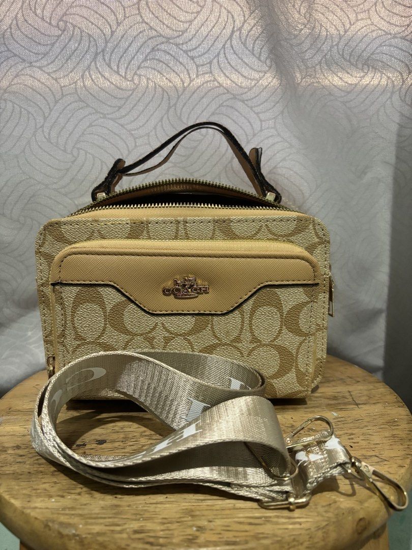 Coach Signature Canvas Mini Vanity Case Bag (Category: Luxury Bags & Wallets) located in Manila. Submitted by mommysoleil (Listing ID 1448172871, Image 3). Description: - Coach mini vanity case - Signature canvas in tan and brown monogram print - Features a top handle - Includes a detachable crossbody strap - Front pocket with Coach logo hardware - Secure zipper closure - Ideal for carrying essentials - Small and compact design.