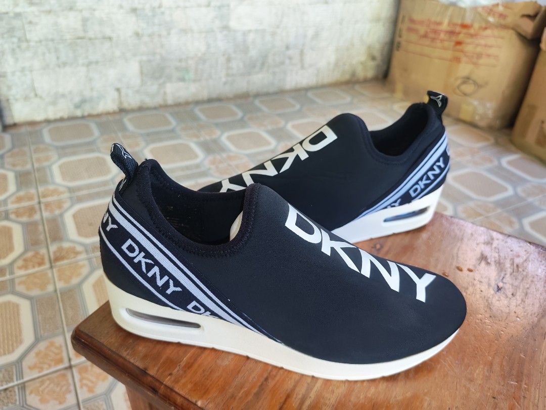 DKNY Black Slip-On Wedge Sneakers (Category: Sneakers) located in Caloocan City. Submitted by erickastella02 (Listing ID 1448137645, Image 2). Description: - Black DKNY slip-on sneakers - Size: 9.5US - EUR 40.5 - Features DKNY logo tape around wedge heel and on shoe - Cushioned sole with clear air bubble detail - Easy slip-on style.