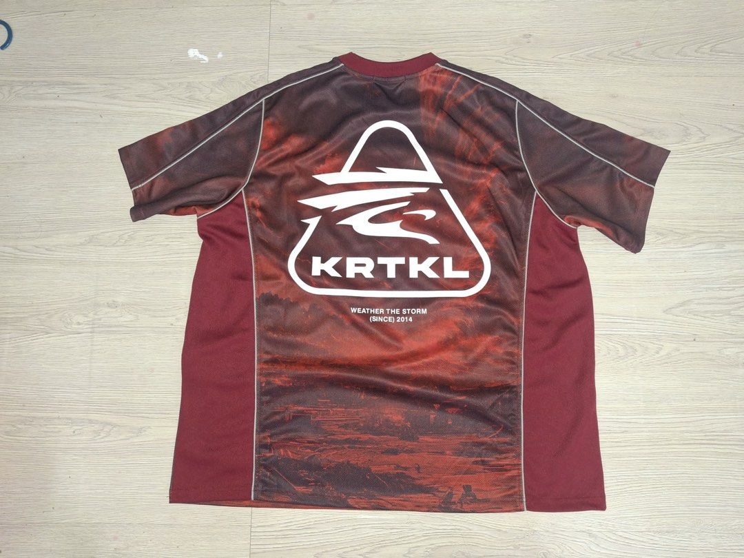 KRTKL AFTERMATH JERSEY (Category: Activewear) located in Kuala Lumpur. Submitted by keeethrift (Listing ID 1448130404, Image 2). Description: - KRTKL T-shirt with 'Weather The Storm' graphic on the front. - Large KRTKL logo on the back. - Unique all-over abstract print in red and brown. - Classic crew neck and short sleeves. - Ideal for everyday casual wear. -PIT 27 L30.