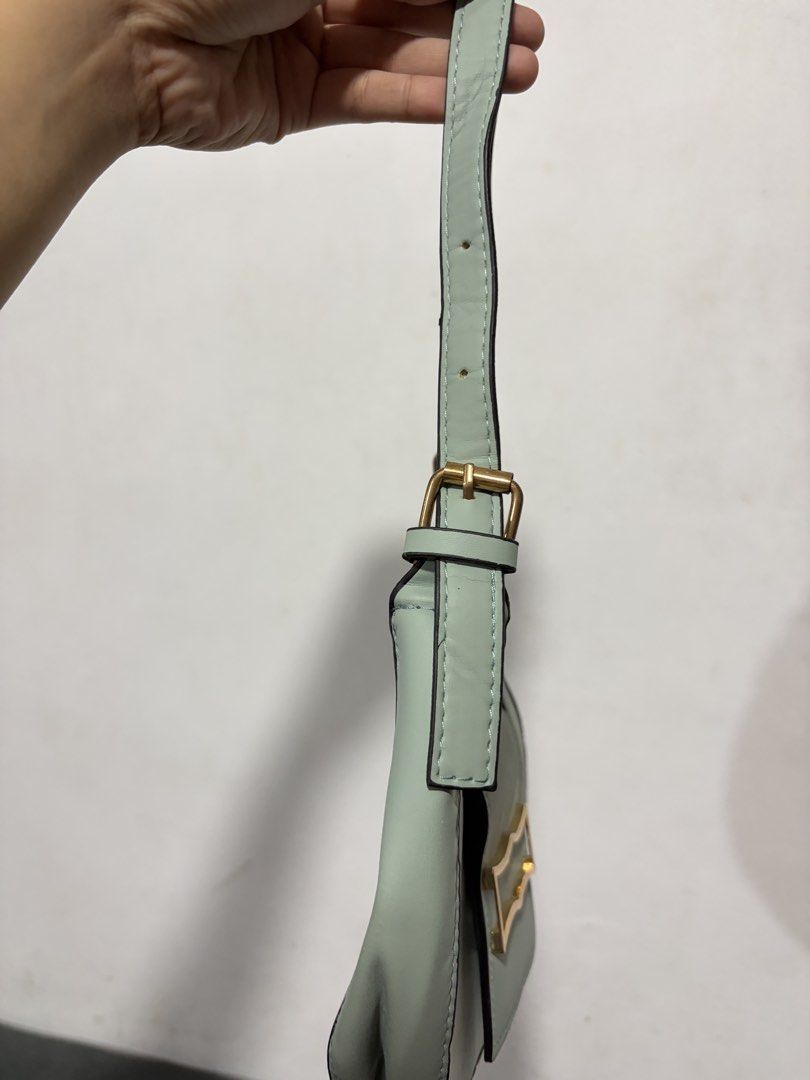 Light Green Crescent Shoulder Bag with Gold Clasp (Category: Shoulder Bags) located in Valenzuela. Submitted by cheaper_finds (Listing ID 1448233039, Image 3). Description: - Trendy light green crescent shoulder bag - Features a chic gold-tone clasp closure - Adjustable strap with buckle for a custom fit - Interior snap closure for added security - Versatile for everyday wear or evening outings.