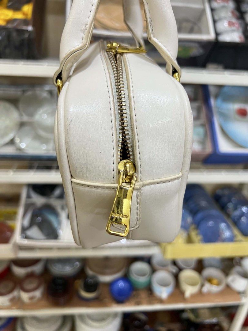 Miu Miu White Leather Boston Bag (Category: Luxury Bags & Wallets) located in Bacolod City. Submitted by novymaesel14868 (Listing ID 1448179648, Image 2). Description: - Authentic Miu Miu boston bag in a stylish white hue. - Crafted from premium leather for a luxurious feel. - Elegant gold hardware accents throughout. - Secure zipper closure to keep your belongings safe. - Interior features a QR code tag for authenticity verification. - Protectiv