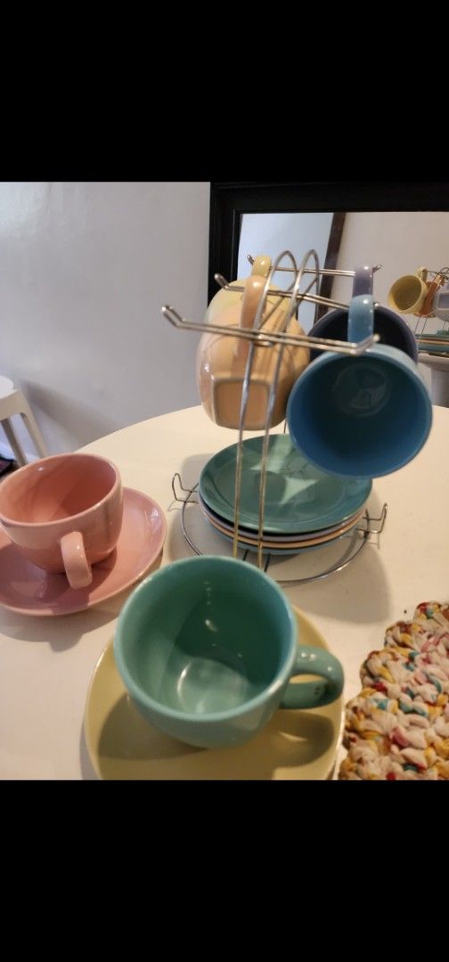 Pastel Ceramic Mugs and Saucers with Rack (Category: Coffee & Tea Tableware) located in Manila. Submitted by babygirl.luxxe (Listing ID 1448089022, Image 1). Description: - Adorable set of pastel mugs and saucers. - Comes with a convenient metal rack for storage. - Features a vibrant color palette: pink, yellow, light blue, teal, and purple. - Ideal for enjoying your favorite coffee or tea. - Adds a charming pop of color to your kitchen space..