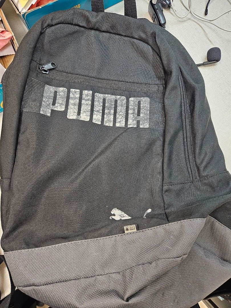 Puma Backpack (Category: Backpacks) located in Singapore. Submitted by edwinsia74 (Listing ID 1448148607, Image 1). Description: - Black Puma backpack - Large Puma logo on front - Smaller Puma logo on side - Multiple zippered compartments - Grey and pink accent on flap - Suitable for school or everyday use.