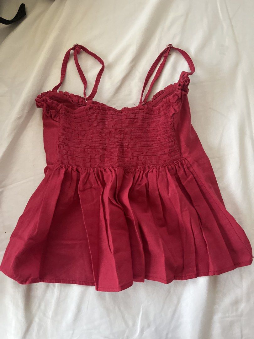 Red Smocked Camisole Top with Ruffle Trim (Category: Sleeveless) located in Quezon City. Submitted by ausieeeee (Listing ID 1448122663, Image 2). Description: - Adorable red camisole top - Features a smocked bodice for a comfortable fit - Adjustable straps for a customizable look - Delicate ruffled trim along the neckline - Slightly flared hem for a flattering silhouette - Versatile for casual outings or dressing up -XS-S.