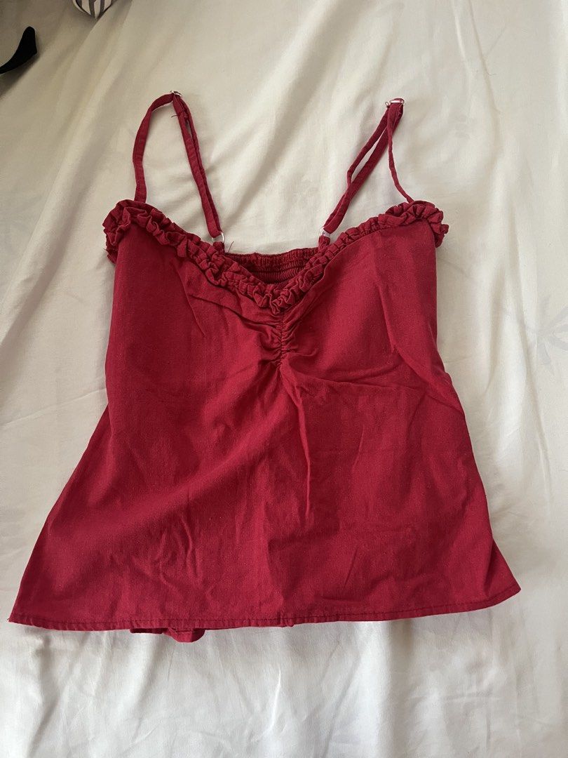 Red Smocked Camisole Top with Ruffle Trim (Category: Sleeveless) located in Quezon City. Submitted by ausieeeee (Listing ID 1448122663, Image 1). Description: - Adorable red camisole top - Features a smocked bodice for a comfortable fit - Adjustable straps for a customizable look - Delicate ruffled trim along the neckline - Slightly flared hem for a flattering silhouette - Versatile for casual outings or dressing up -XS-S.