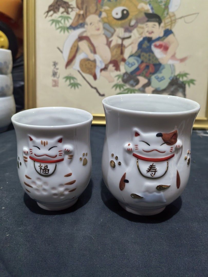 Teacups - Japanese Yunomi-style Ceramic Cup - Pair (Category: Coffee & Tea Tableware) located in Cebu City. Submitted by dudes_villanueva (Listing ID 1448133404, Image 1). Description: Teacups - Japanese Yunomi-style Ceramic Cup - Pair 📌 Features a raised, three-dimensional maneki-neko (lucky cat) design with gold-painted accents.. Big : Height - 3.75 in Small : Height - 3.10 in.